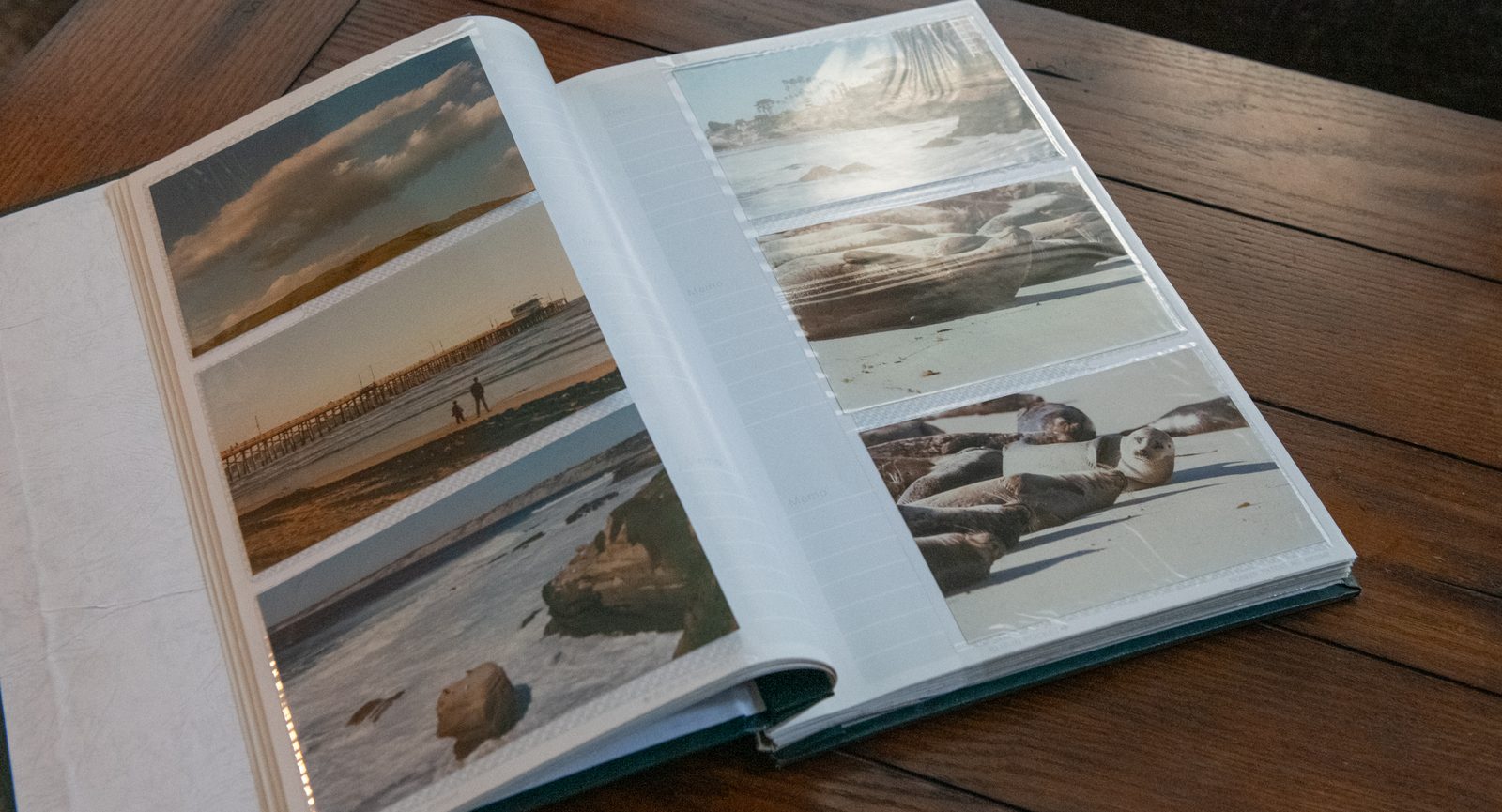 An open scrapbook album showing scanned beach and coastline photos
